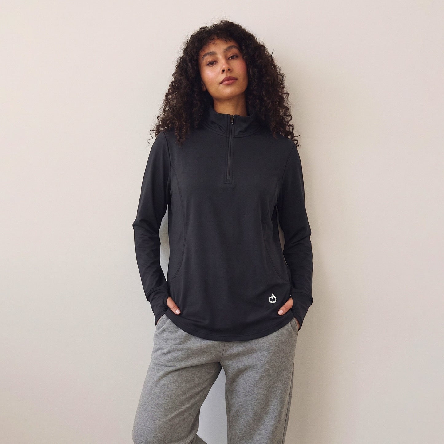 Model wearing Meryia black longline half-zip top with breathable fabric and seam detailing for activewear