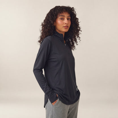 Meryia RASM black longline half-zip top with breathable fabric and seam detailing worn by a woman with curly hair. | Meryia مِرية